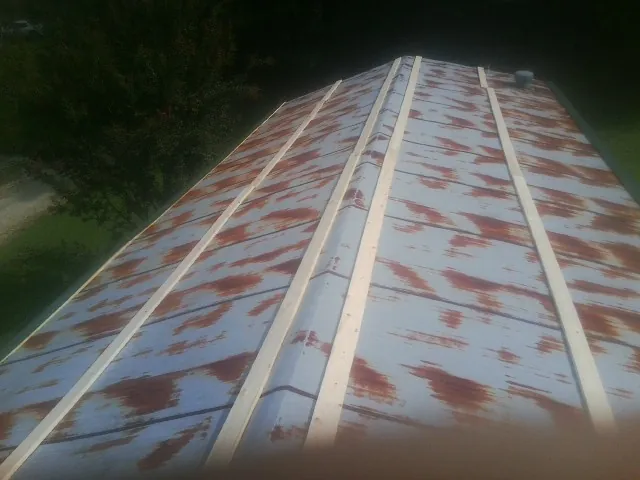 Rusted metal roof panels with new wood purlins before replacement — Storm Damage Roof Repair in Balm by Roofing Brothers