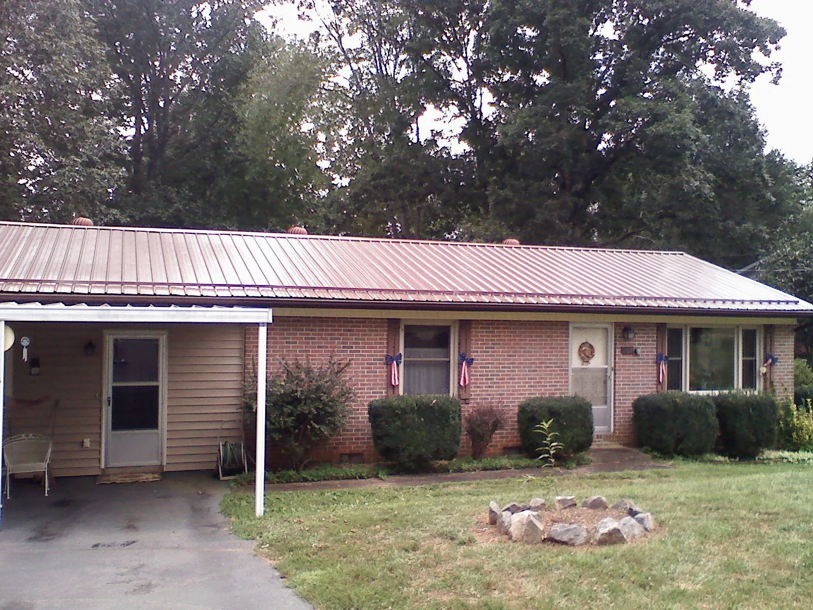 Bronze metal roof and carport on a brick ranch home — Roof Repair work by our crew in Balm